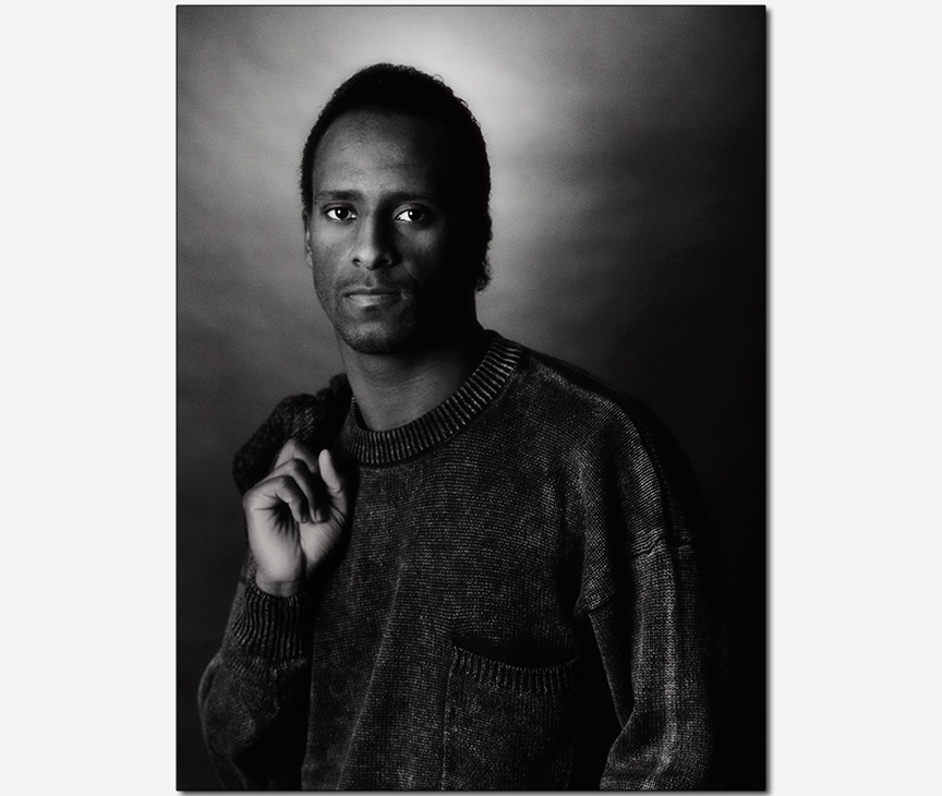 African-American male model with coat draped over shoulder